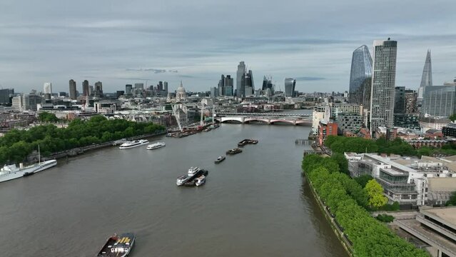 Dolly shot of boats and ferries on the Thames river in London on a cloudy day