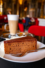Piece of famous Sachertorte chocolate cake with apricot jam of Austrian origin served with whipped...