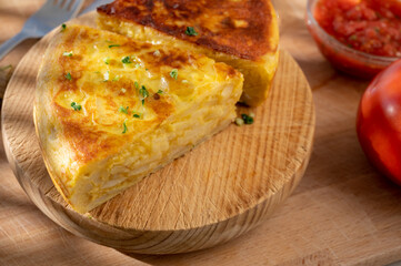 Spanish vegetarian food, portion of homemade potato omelette tortilla de patatas with onion served outdoor in morning sunlights