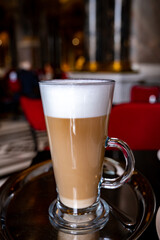 Glass cup of coffee latte served in classic old Austrian café-restaurant in Vienna