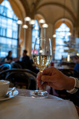Lifestyle of beautiful Vienna, glass of white dry Austrian wine served in old Viennese-style cafe in Vienna, Austria