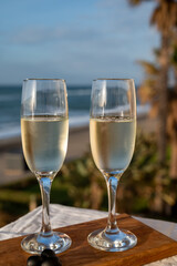 Glasses of Spanish cava sparkling wine and view on blue sea and sandy beach, Costa del Sol vacation destination, Andalusia, Spain