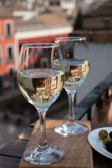 Two glasses of Spanish dry rueda white wine served on roof terrace with view on old part of Andalusian town Granada, Spain