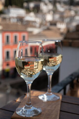 Two glasses of Spanish dry rueda white wine served on roof terrace with view on old part of Andalusian town Granada, Spain