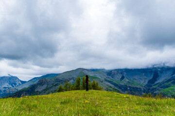 Obraz premium A wide angle shot of a young female hiker on a break during a hike on a cloudy summer day in the French Alps (Valberg, Alpes-Maritimes, France)