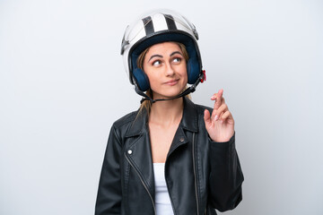Young caucasian woman with a motorcycle helmet isolated on white background with fingers crossing and wishing the best