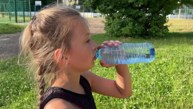 a little girl in sportswear goes in for sports and drinks water after a workout, a healthy lifestyle, sports and physical education