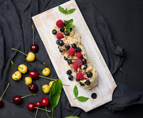 Baked cake made from whipped chicken protein and cream, decorated with fresh berries. Dessert Pavlova