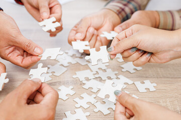 Close up Businesspeople hand holding jigsaw and jigsaw puzzle on the table, success and strategy concept.