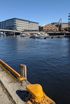 Vertical shot of Central Bay in the in Trondheim with yellow port bollar in front