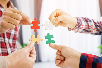 Close up Businesspeople hand holding jigsaw puzzle in a circle on the table, success and strategy concept.