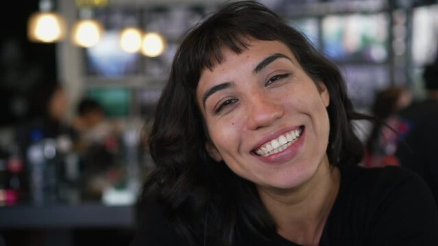 Portrait of a hispanic latin girl smiling at camera sitting at restaurant cafe