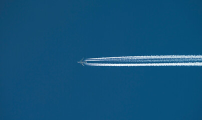 Airplane with a long reverse trail in the blue sky