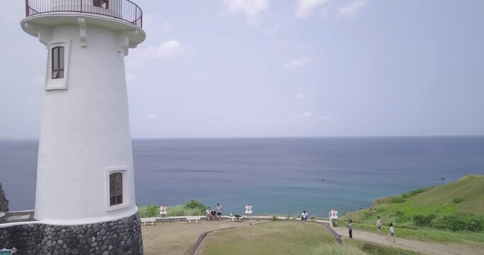 Drone footage of the Basco Lighthouse on the shore in Batanes, Philippines with a view of the ocean