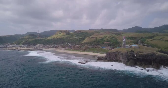 Drone footage of the ocean and the BascoLighthouse on the shore in Batanes, Philippines