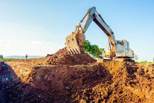 Excavator machine working and digging ground on blurred background