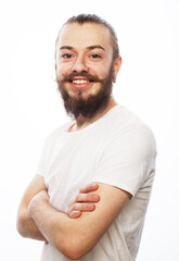 Handsome young man in white t-shirt looking at camera standing with crossed arms over white...