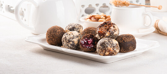 Handmade chocolate truffles on a light background. Kitchen table with white tablecloth and crockery