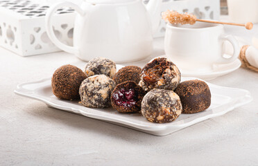 Handmade chocolate truffles on a light background. Kitchen table with white tablecloth and crockery