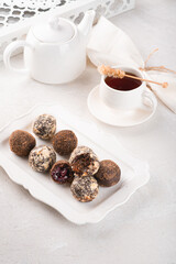Handmade chocolate truffles on a light background. Kitchen table with white tablecloth and crockery
