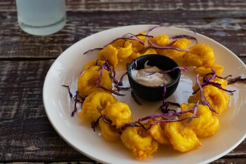 Delicious seafood meal of deep-fried golden squid rings on an platter