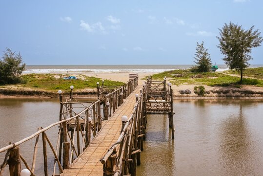Wooden footbridge over a river on a Beach in Goa India.