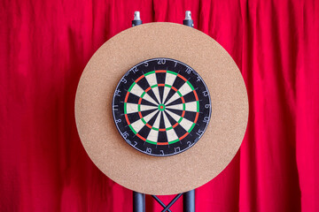 Dartboard at an event location with a red curtain behind it
