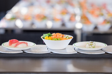 Poke-bowl with salmon and sushi on a sushi conveyor belt