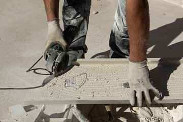 Albañil cortando con la radial una loseta.