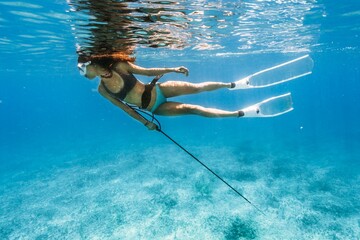 Female spearfishing under the water in the Bahamas