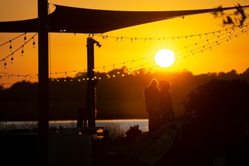 Obraz premium A couple standing admiring sunset in Charleston, SC