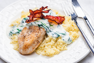poultry breast with spinach creamy sauce and bacon served with couscous