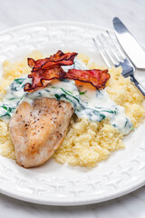 poultry breast with spinach creamy sauce and bacon served with couscous