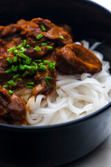 meat with sauce served with rice noodles