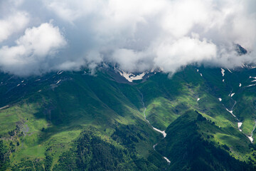 Clouds over the mountains and green hills.