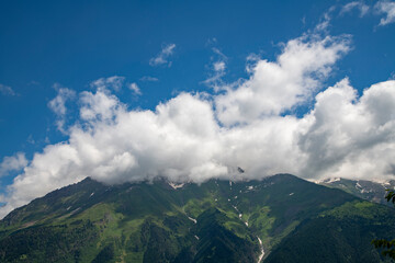 Clouds over the mountains and green hills.