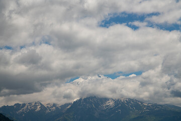 Beautiful snow covered mountains with in the fog and dramatic clouds.