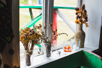 withered bouquets of flowers on the windowsill