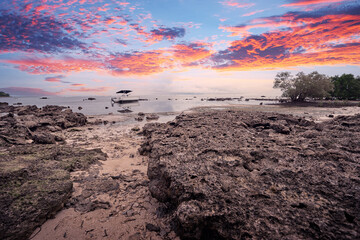 Beautiful landscape with colorful sunset on the low tide tropical beach.