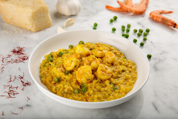 SAFFRON RISOTTO WITH SHRIMPS served in a dish isolated on grey background side view