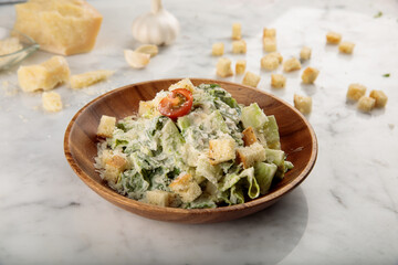 Healthy CEASAR SALAD with garlic served in a dish isolated on grey background side view