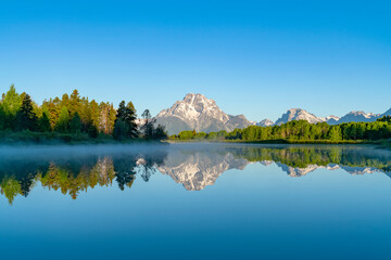 landscape of snow mountain reflecting in the lake in the morning