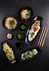 Various dishes of Asian cuisine with different types noodles and rice with shrimp, duck, vegetables and black sesame
