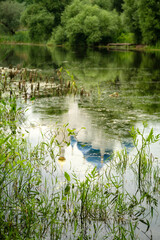 Domes of orthodox chirch reflects in lake waters