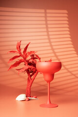 Cocktail glass and palm tree on a pink background. - Summer concept