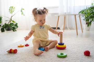 Eco friendly plastic free toys for toddler. Little girl making her first step while playing alone...