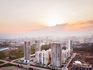 Tbilisi, Georgia - 15th october, 2021: Aerial view Diamond apartment complex high real estate buildings complex in city suburbs with polluted hazy sky and sunset background