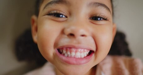 Playful little child smiling for an orthodontist and feeling confident for her oral hygiene dental appointment. Closeup of the face of a cute little girl showing her teeth during a dentist check up.