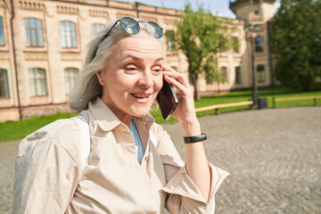 Happy female person using telephone for pleasant talk, copy space