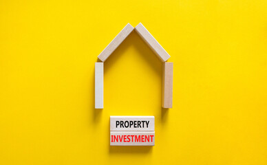 Fototapeta na wymiar Property investment symbol. Concept words Property investment on wooden blocks on a beautiful yellow table yellow background. Wooden house model. Business Property investment concept. Copy space.